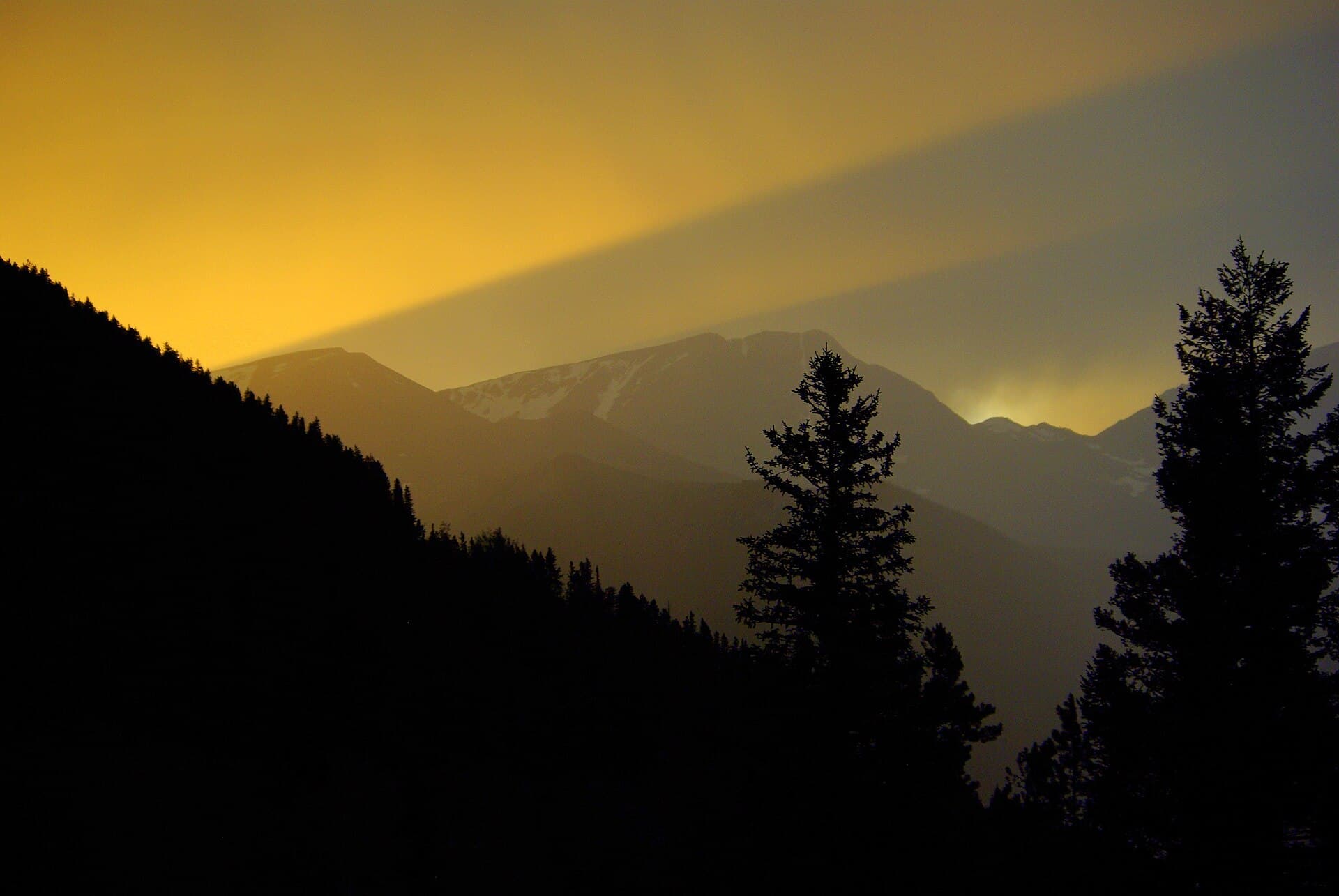 A storm developing above a high mountain trail road at sunset